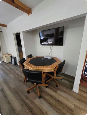 A conference room with a round table, black chairs, a flat-screen TV mounted on the wall, and a wooden ceiling. - Near BassLake, sleeps 16, BBQ, Game Room (Bass Lake)