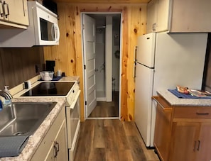 Eine kleine Küche mit Mikrowelle, Kühlschrank und Spüle.