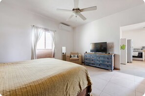 A bedroom with a bed, a television, a dresser, and a kitchenette. - El Sol: apartment with rooftop lounge access minutes from 5 Avenida (Playa del Carmen)