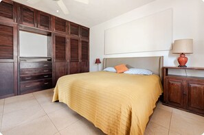 Ein Schlafzimmer mit Bett, Kleiderschrank, Lampe und Deckenventilator.