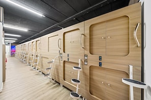 A row of wooden lockers with metal handles and numbered tags, indicating a self-service storage area. - Paradise Pods (Surfers Paradise)