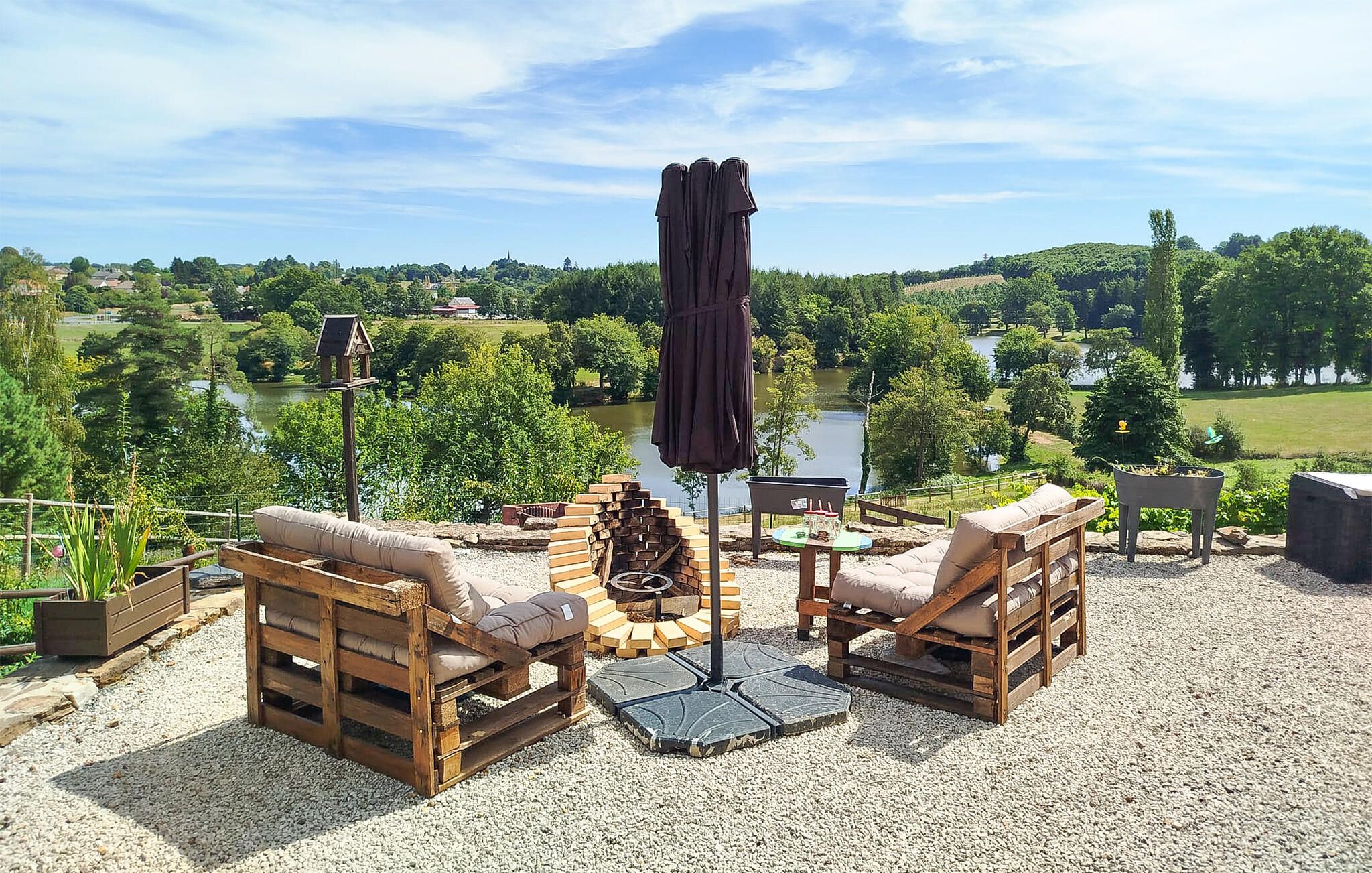 Een buitenplaats met houten meubels, een tafel en een barbecue.