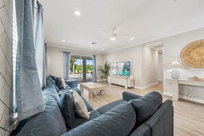 Un salon moderne avec un canapé, une table basse et un tableau accroché au mur.