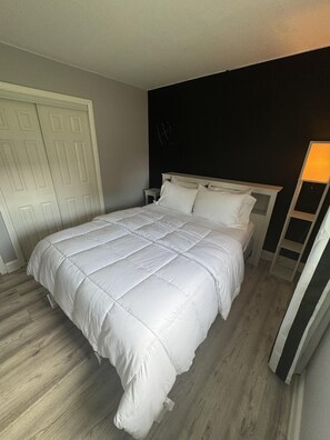A bedroom with a bed, a nightstand, a wardrobe, and a lamp. - Welcome to Getaway on the Bay | Your Waterfront Annapolis Escape (Annapolis)