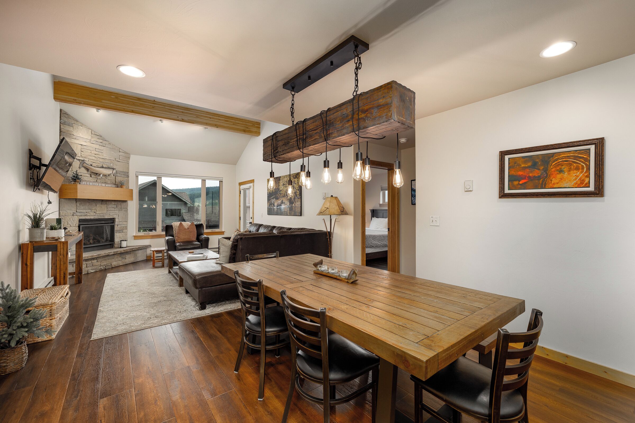 A spacious living area with a wooden dining table, leather seating, and a fireplace.