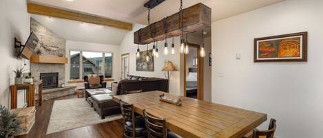 A spacious living area with a wooden dining table, leather seating, and a fireplace.