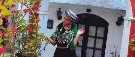 Una persona de pie frente a un edificio con puerta negra y un arco.