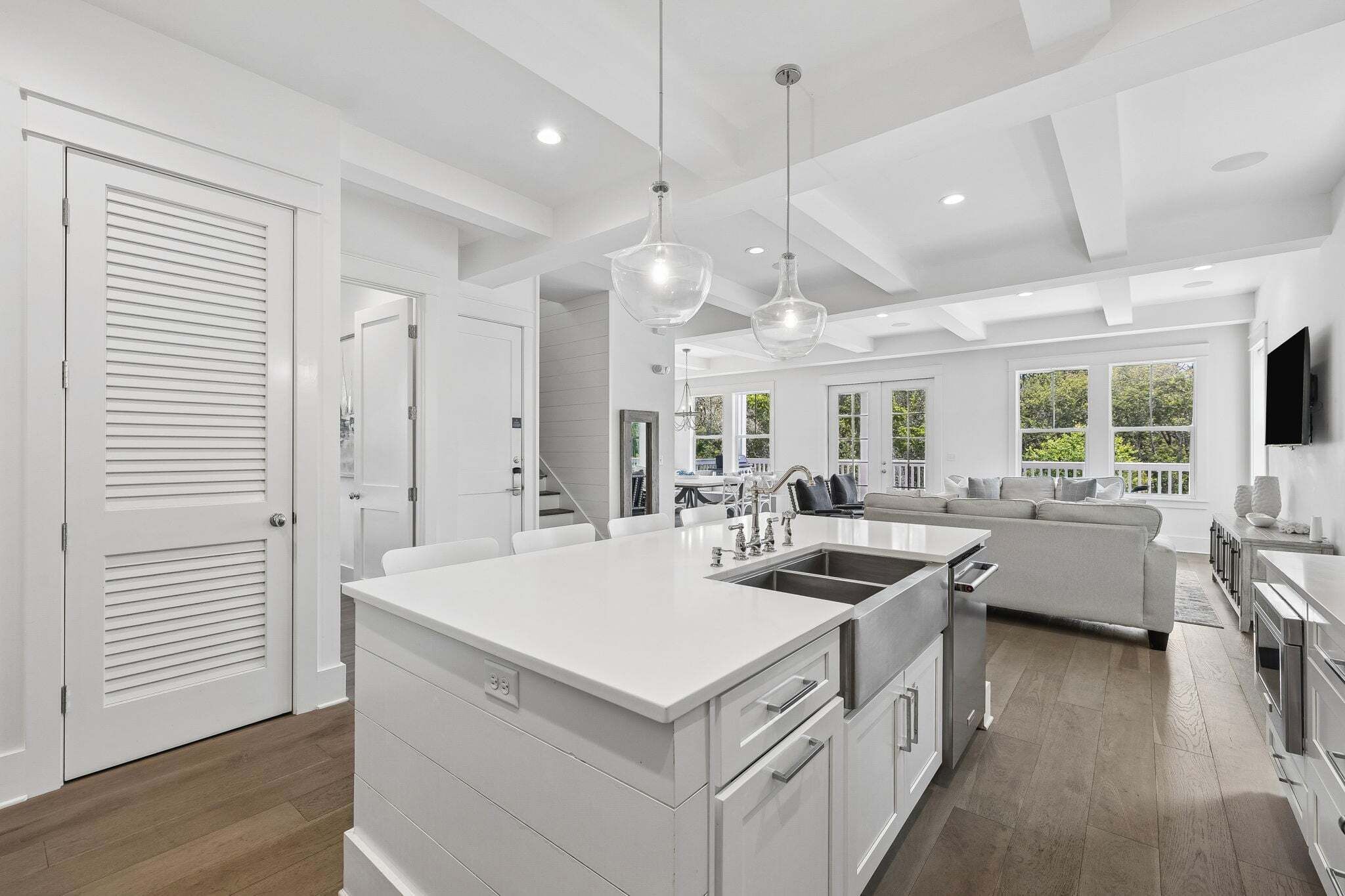 A modern kitchen with a central island, stainless steel appliances, and pendant lighting.
