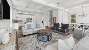 A spacious living area with a sofa, coffee table, and dining table. - Easy Walk 2 Beach! Private Pool, LSV/Golf Cart & Bikes! (Santa Rosa Beach)