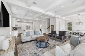 A spacious living area with a sofa, coffee table, and dining table. - Easy Walk 2 Beach! Private Pool, LSV/Golf Cart & Bikes! (Santa Rosa Beach)