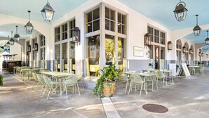 A cafe with outdoor seating, large windows, and hanging lanterns. - Easy Walk 2 Beach! Private Pool, LSV/Golf Cart & Bikes! (Santa Rosa Beach)