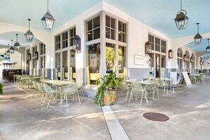 A cafe with outdoor seating, large windows, and hanging lanterns. - Easy Walk 2 Beach! Private Pool, LSV/Golf Cart & Bikes! (Santa Rosa Beach)
