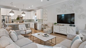 A modern kitchen with white cabinets, stainless steel appliances, and pendant lighting. - NEW! EZ Walk to Beach! Private Pool, LSV/Golf Cart, & Bikes! (Santa Rosa Beach)