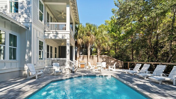 A swimming pool with lounge chairs and a barbecue area, surrounded by trees and a building with balconies. - NEW! EZ Walk to Beach! Private Pool, LSV/Golf Cart, & Bikes! (Santa Rosa Beach)