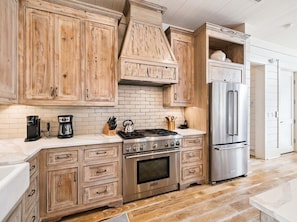 A kitchen with wooden cabinets, a stainless steel refrigerator, a gas stove, and a built-in oven. - SOUTH of 30A in WaterColor on Park Row! Loaded! (Santa Rosa Beach)