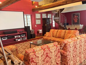 A living room with a red sofa, a coffee table, a fireplace, and a staircase.