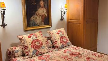 Une chambre à coucher avec un lit, un tableau et deux appliques murales.