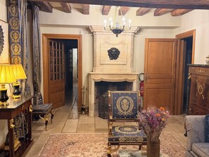 A traditional room with a fireplace, ornate furniture, and a chandelier.