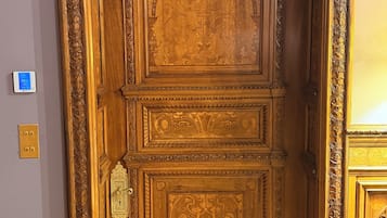 Une porte en bois ornée de sculptures complexes et dotée d’une poignée en laiton.