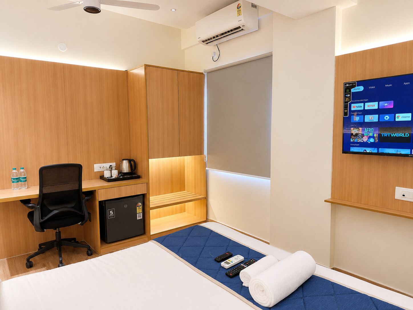 Une chambre d’hôtel équipée d’un lit, d’un bureau, d’une chaise et d’un téléviseur fixé au mur, qui permet d’accéder à différentes applications.