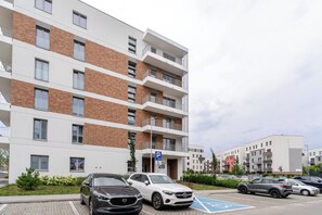 Un edificio residencial de varios pisos con un área de estacionamiento.