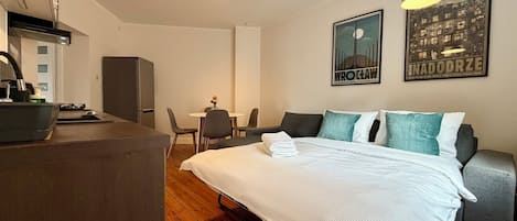 Una habitación de hotel moderna con cama, escritorio, silla y mesa de comedor.