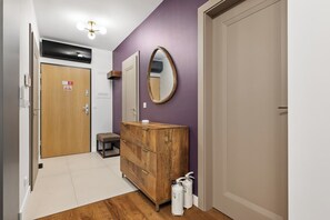 A hallway with a wooden vanity, a mirror, and two toiletry bottles. - Lubomelska City Prestige 54 Apartment (Lublin)