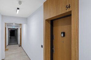 A hallway with a wooden door labeled '54' and a keypad lock. - Lubomelska City Prestige 54 Apartment (Lublin)
