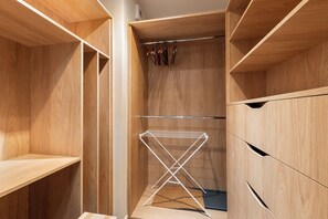 Ein Holzschrank mit offenen Regalen, einer Kleiderstange und einem Wäscheständer.