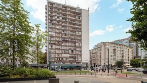 A multi-story residential building with balconies, a pedestrian crossing, and a traffic light. - Puławska Urban Nest Apartment (Warszawa)