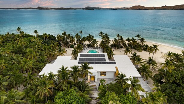 A resort with a pool, palm trees, and a beach view.