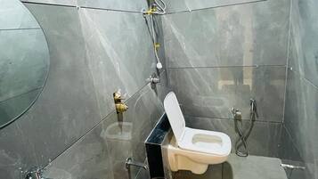 A bathroom with a toilet, sink, and shower.