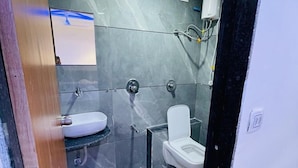 Un baño moderno con inodoro, lavamanos y ducha.