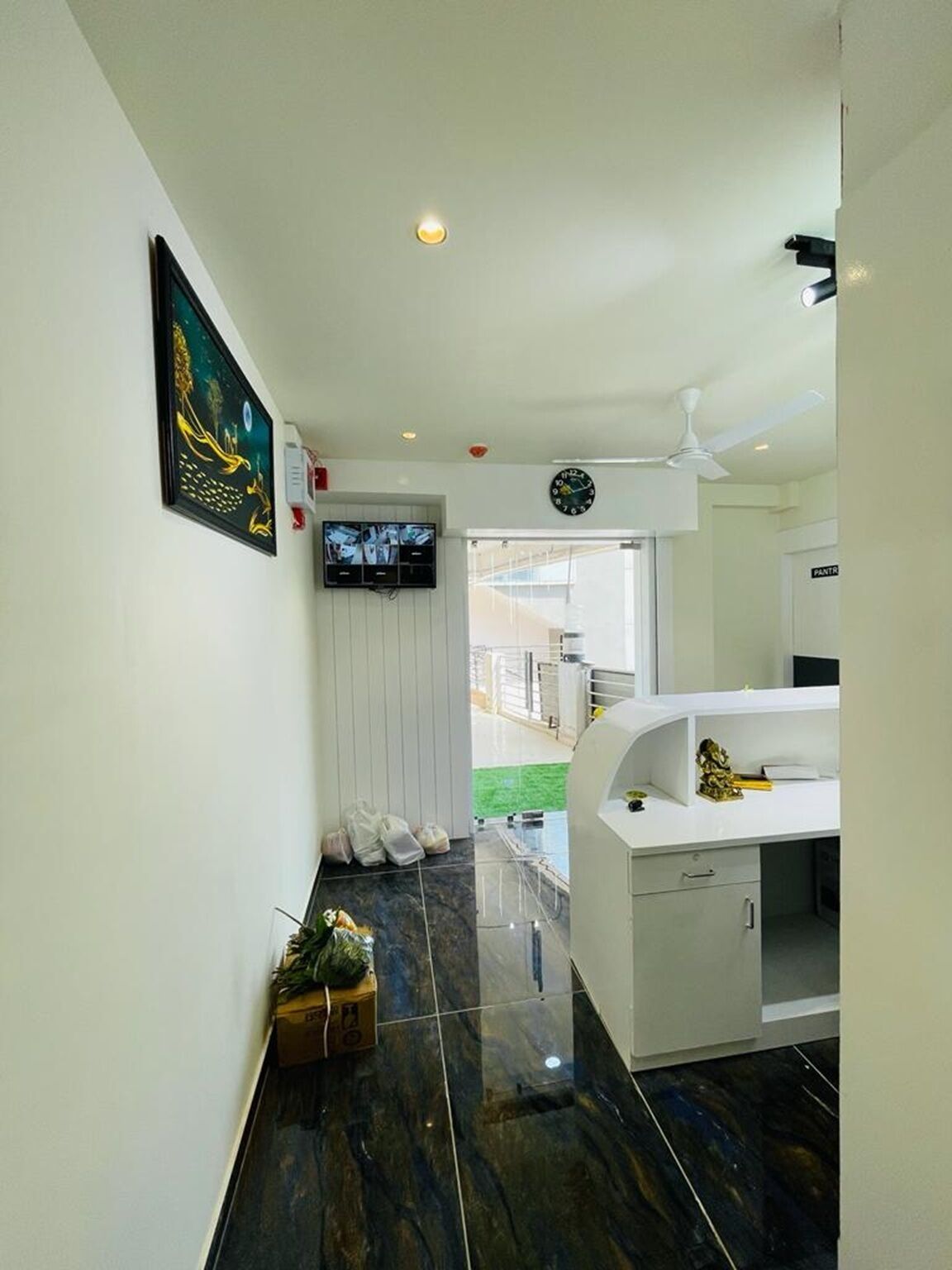 Un baño moderno con un tocador blanco, un espejo y un reloj en la pared.