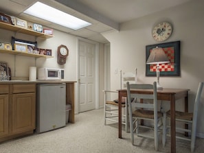 A kitchen with a microwave, a refrigerator, a dining table with chairs, a clock, and a framed picture on the wall. - The Haven Adjoining houses for large groups/families Lake Junaluska (Lake Junaluska)