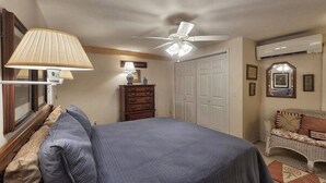 A bedroom with a bed, dresser, ceiling fan, and a wall-mounted air conditioner. - The Haven Adjoining houses for large groups/families Lake Junaluska (Lake Junaluska)