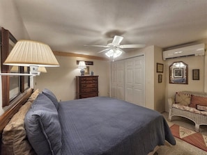 A bedroom with a bed, dresser, ceiling fan, and a wall-mounted air conditioner. - The Haven Adjoining houses for large groups/families Lake Junaluska (Lake Junaluska)