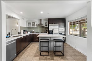 A modern kitchen with a central island, stainless steel appliances, and a large window. - Scottsdale Old Town Palm Oasis 🌵⛳ Heated Pool, Ping Pong Near Old Town (Scottsdale)