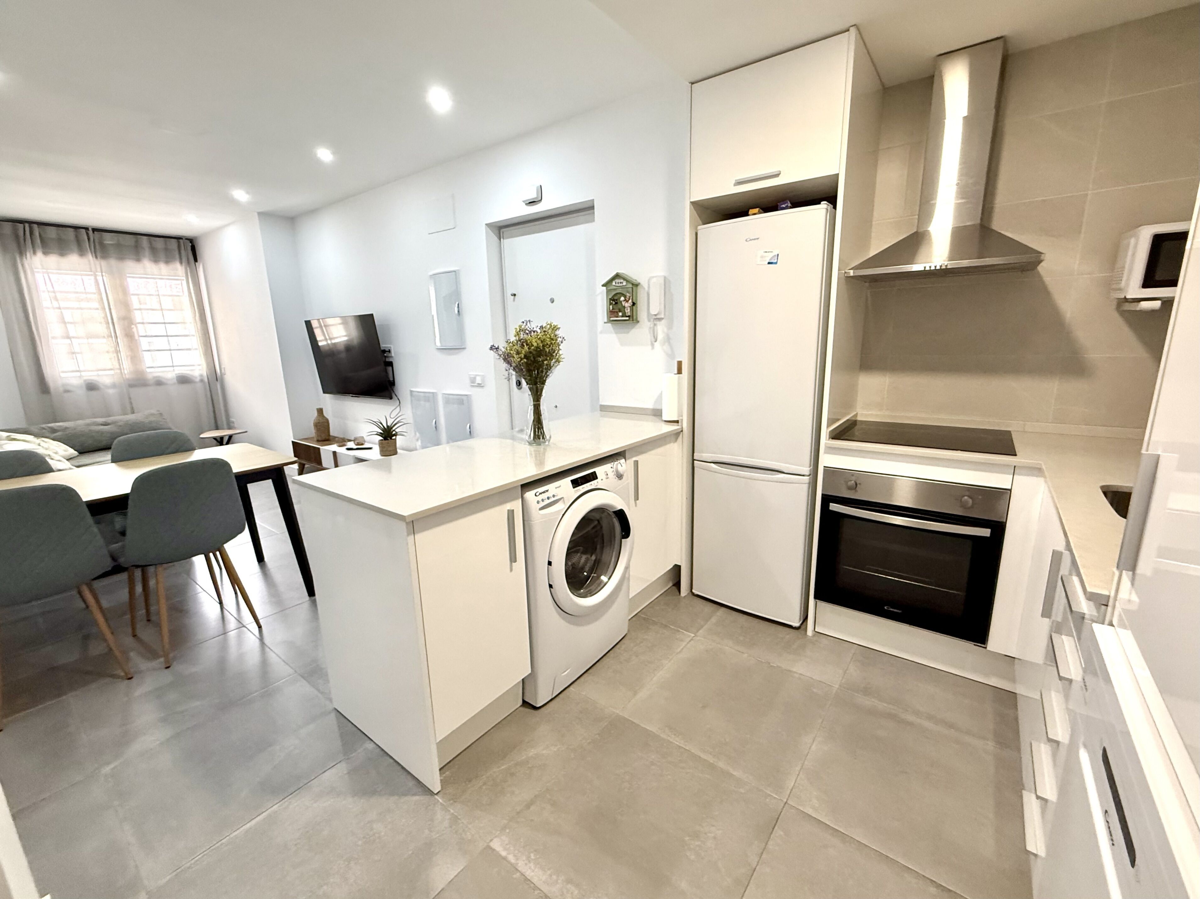 A compact kitchen with a built-in washing machine, a microwave, and a stove.