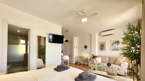 Een moderne hotelkamer met een groot bed, een bureau, een bank en een televisie.