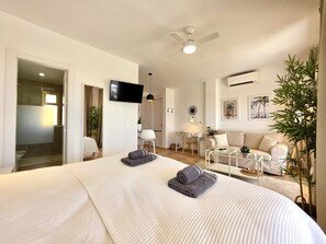 A modern hotel room with a large bed, a desk, a sofa, and a television. - SR Romana Playa 545 Studio with a Wonderful Ocean View (Marbella)