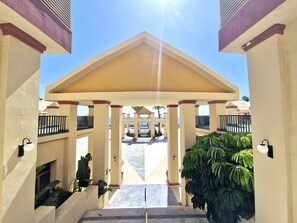 A hotel entrance with a covered walkway, columns, and potted plants. - SR Romana Playa 545 Studio with a Wonderful Ocean View (Marbella)