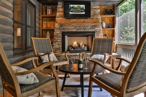 A cozy cabin interior with a fireplace, wooden furniture, and a sign above the fireplace. - Chestnut Hills Lodge by Mountain Oasis | Luxury Blue Ridge Cabin (Blue Ridge)