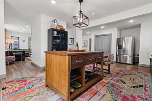 A modern kitchen with a central island, stainless steel appliances, and a patterned rug. - Private pool, walk to downtown Springdale, dogs welcome, close to U of A. (Springdale)