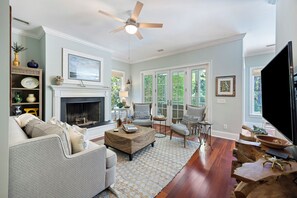 A spacious living room with a fireplace, comfortable seating, and a large television. - Private Pool on Governors Drive! Close to Allee of Oaks (Kiawah Island)