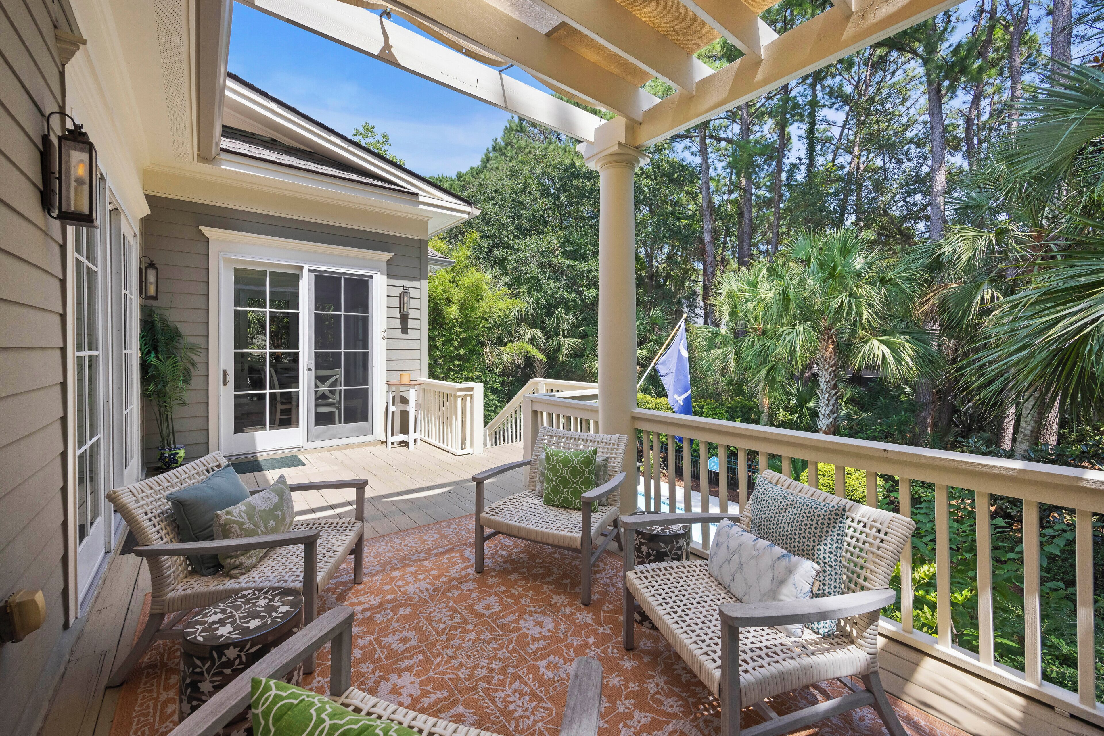 A covered porch with wicker furniture and a flag.