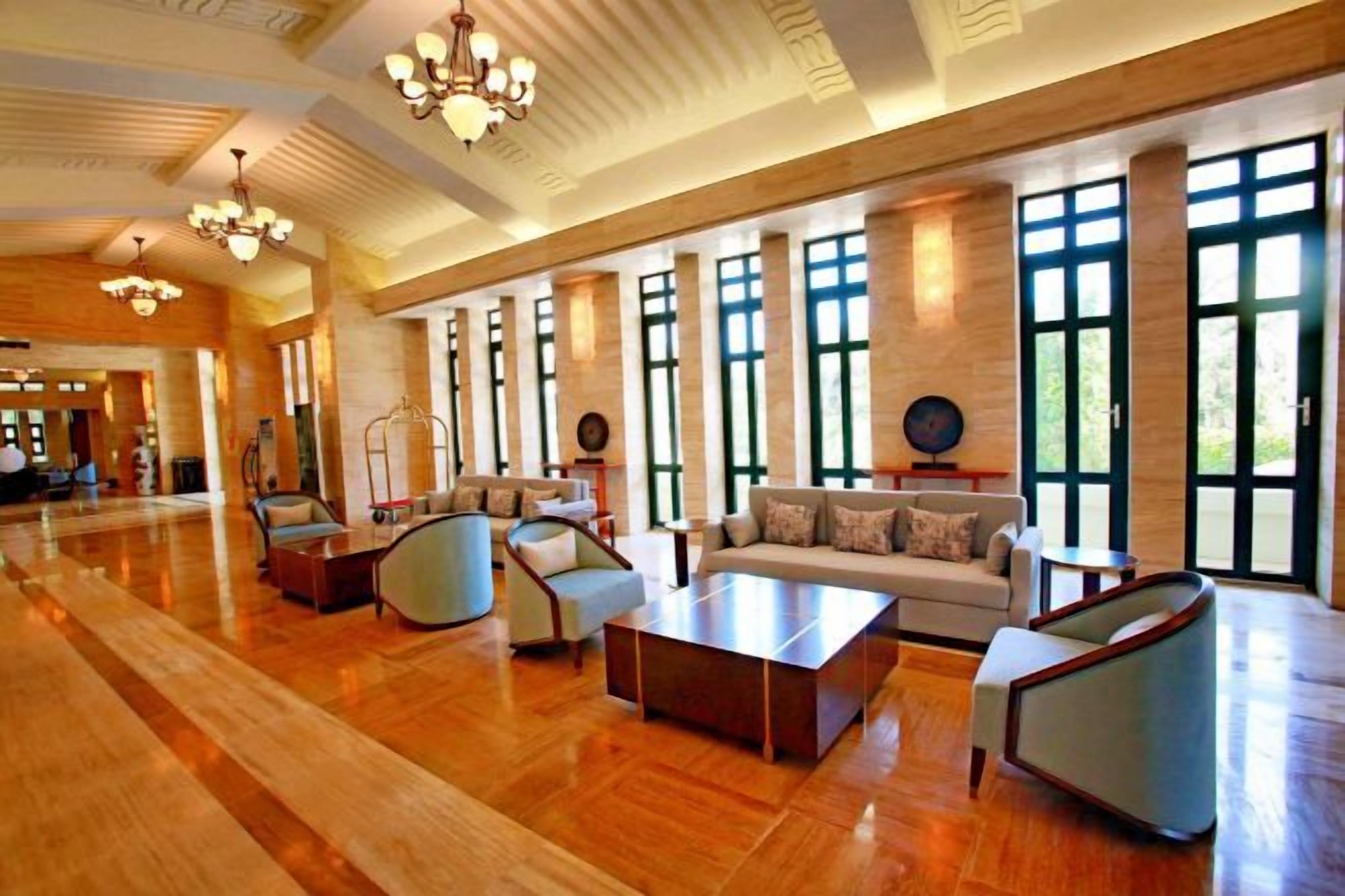A spacious lobby with a high ceiling, large windows, and a variety of seating arrangements.