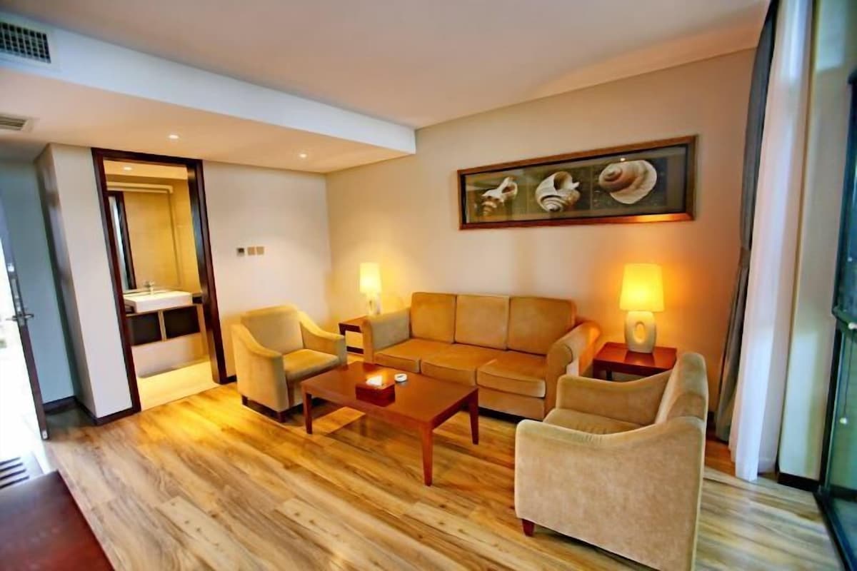A living room with a sofa set, two armchairs, a coffee table, and two bedside lamps.