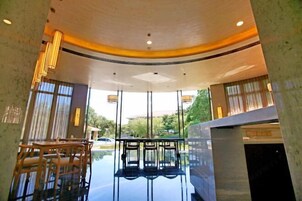 Un espacio interior amplio con techo curvo, ventanas grandes y una disposición de asientos.