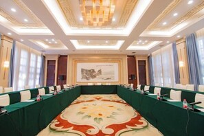 A conference room with a long table, chairs, and microphones.